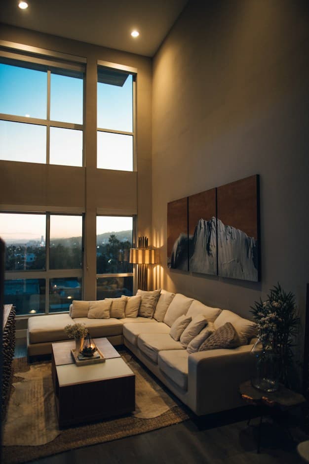 Modern living room with high ceilings, large windows, and a cream sectional
